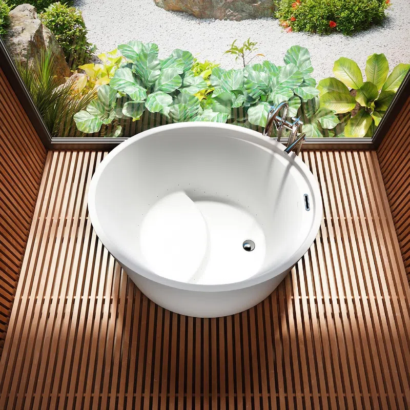 White round bathtub on wooden slat floor with large window and green garden outside