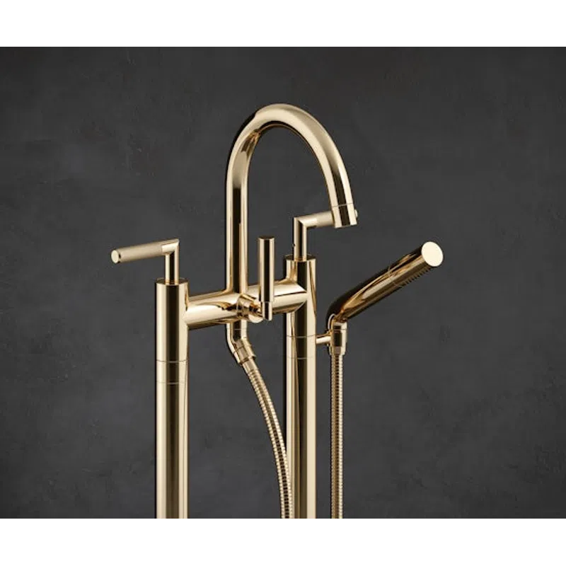 Modern gold freestanding bathtub faucet with handheld shower against dark gray background