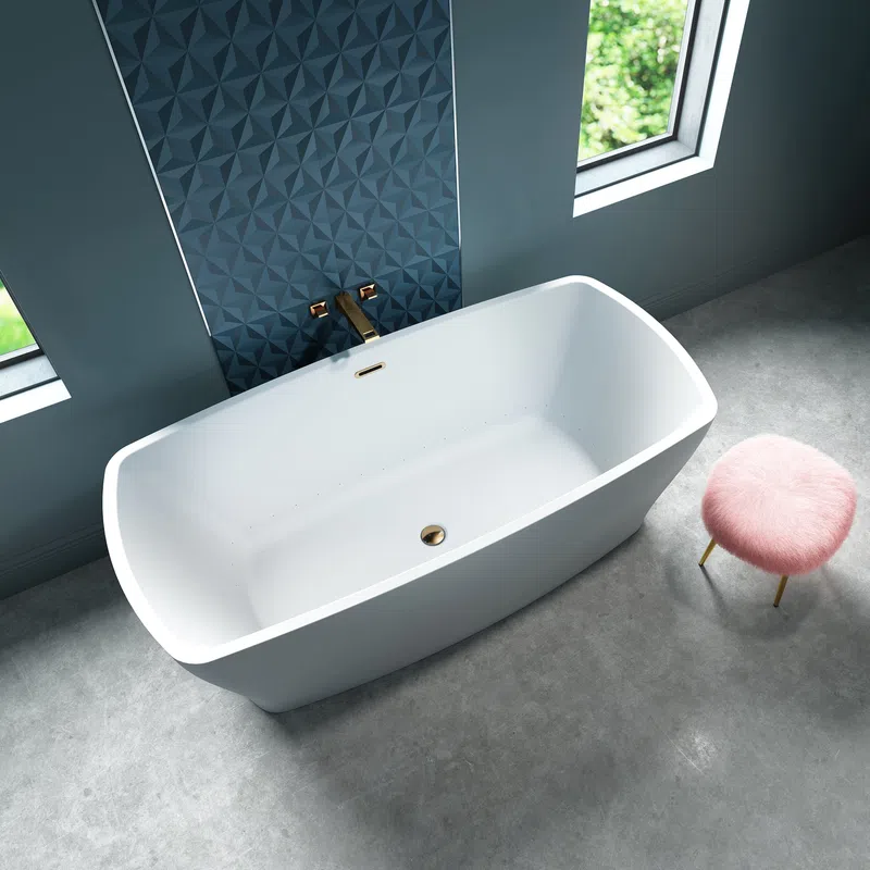 Modern white freestanding bathtub with gold fixtures next to a blue textured wall and pink fluffy stool.