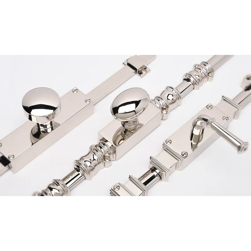 Close-up of polished silver door latches with round and oval knobs on a white background.