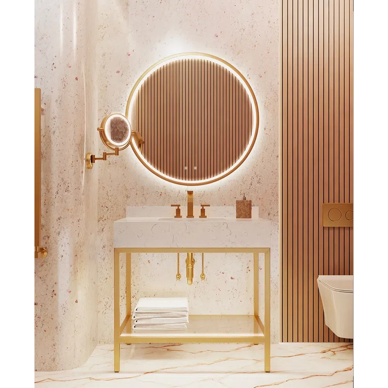 Modern bathroom with illuminated round mirror, gold fixtures, white marble sink, and stacked towels under vanity.