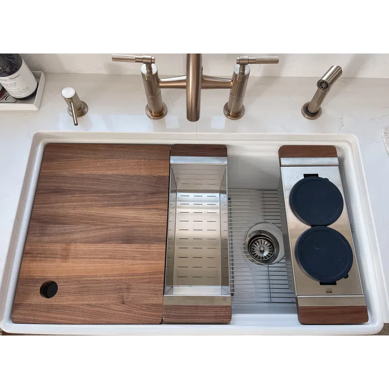 Modern kitchen sink with brass faucet, removable wood covers, stainless steel drying rack, and accessories