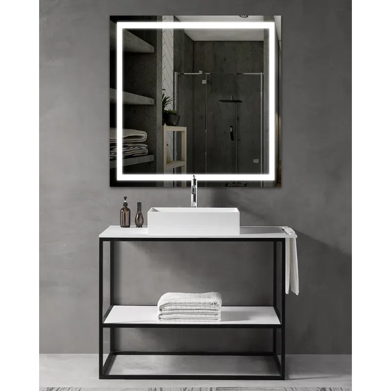Modern bathroom vanity with illuminated square mirror, white sink, folded towels, and gray concrete walls.