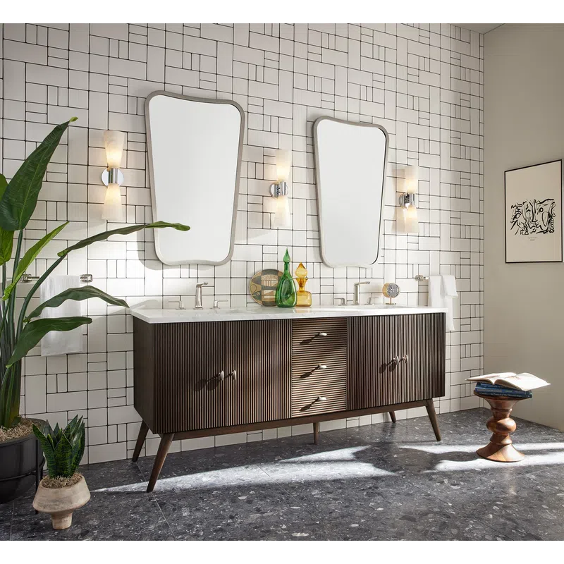 Modern bathroom with mid-century wooden double vanity, two unique mirrors, and geometric white tiled wall.