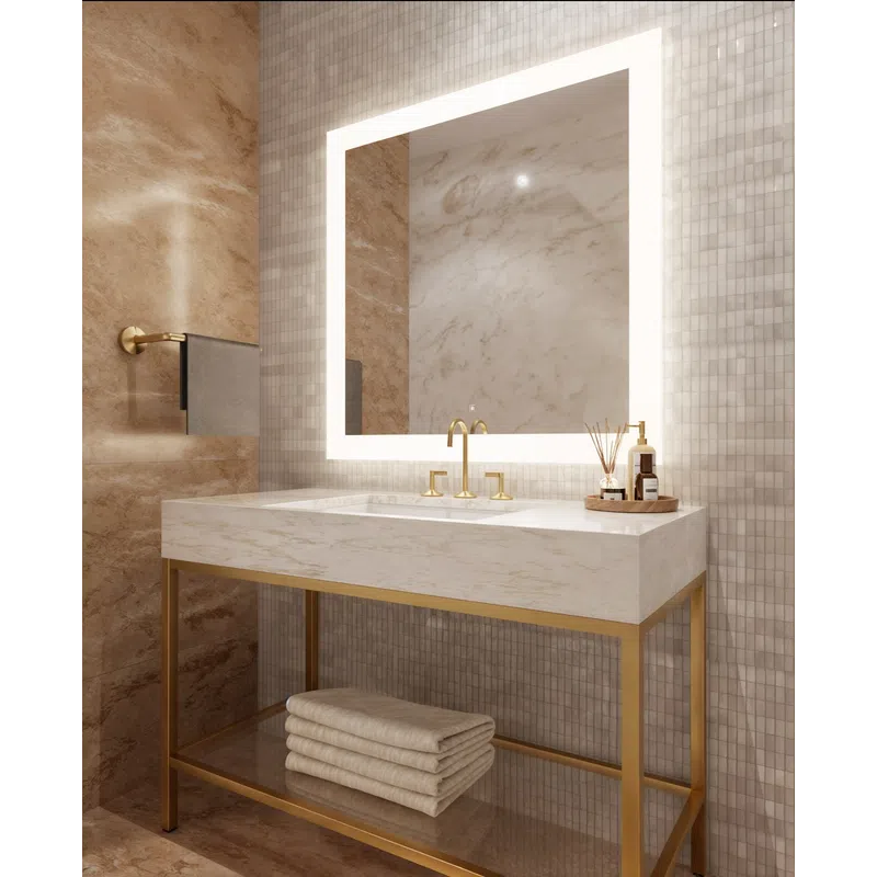 Modern bathroom vanity with marble countertop, gold fixtures, illuminated square mirror, and neatly stacked towels.