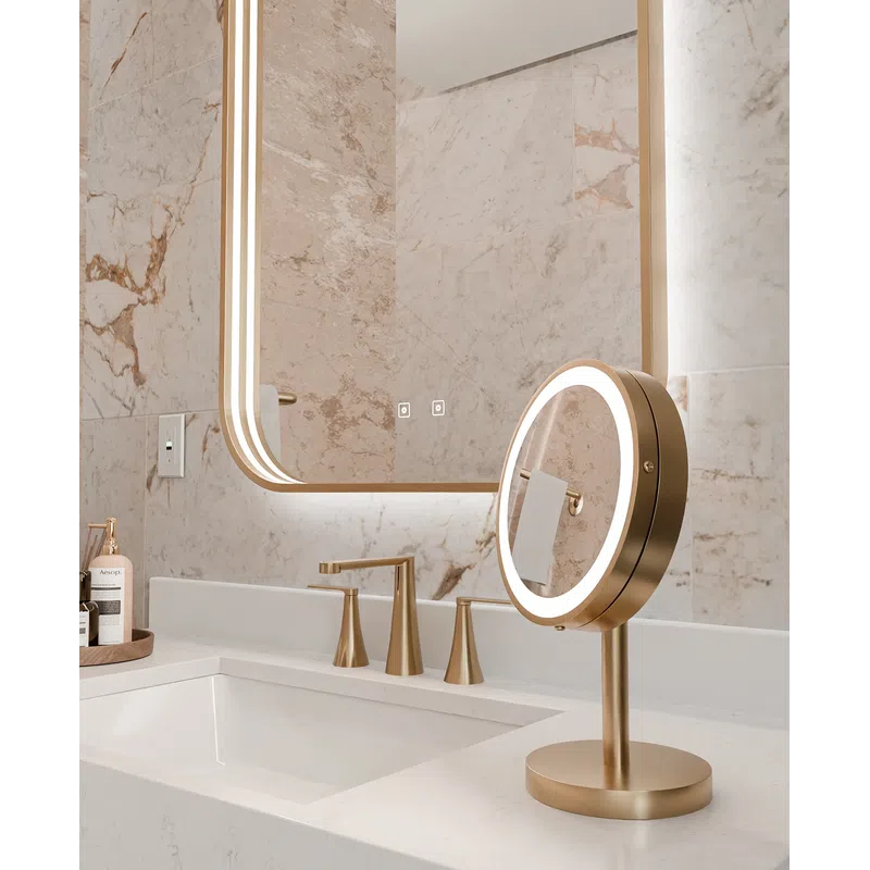 Modern bathroom sink with gold fixtures, illuminated round vanity mirror, and marble walls for a luxurious look.