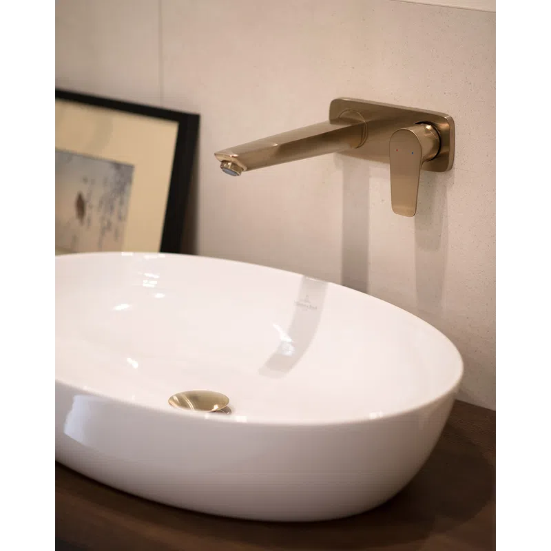 Modern white oval bathroom sink with a wall-mounted brushed metal faucet and single lever handle.