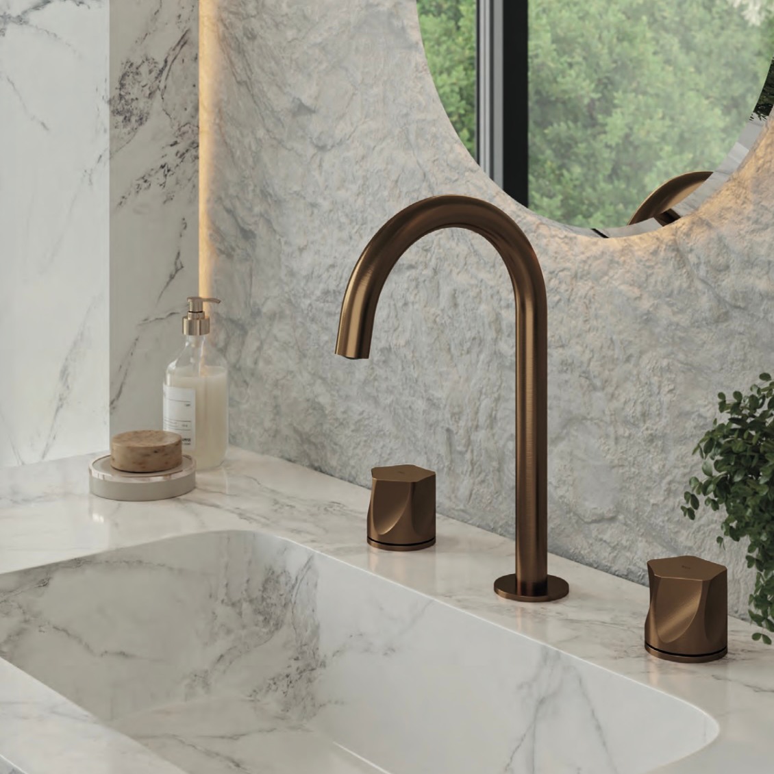 Modern bathroom sink with bronze faucet, marble countertop, round mirror, and natural light from window.