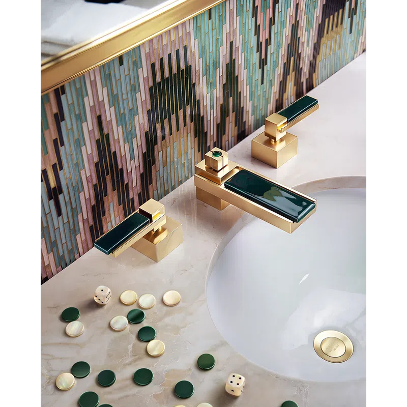 Gold and dark green faucet on marble sink with colorful geometric tile backsplash and game pieces scattered on countertop.