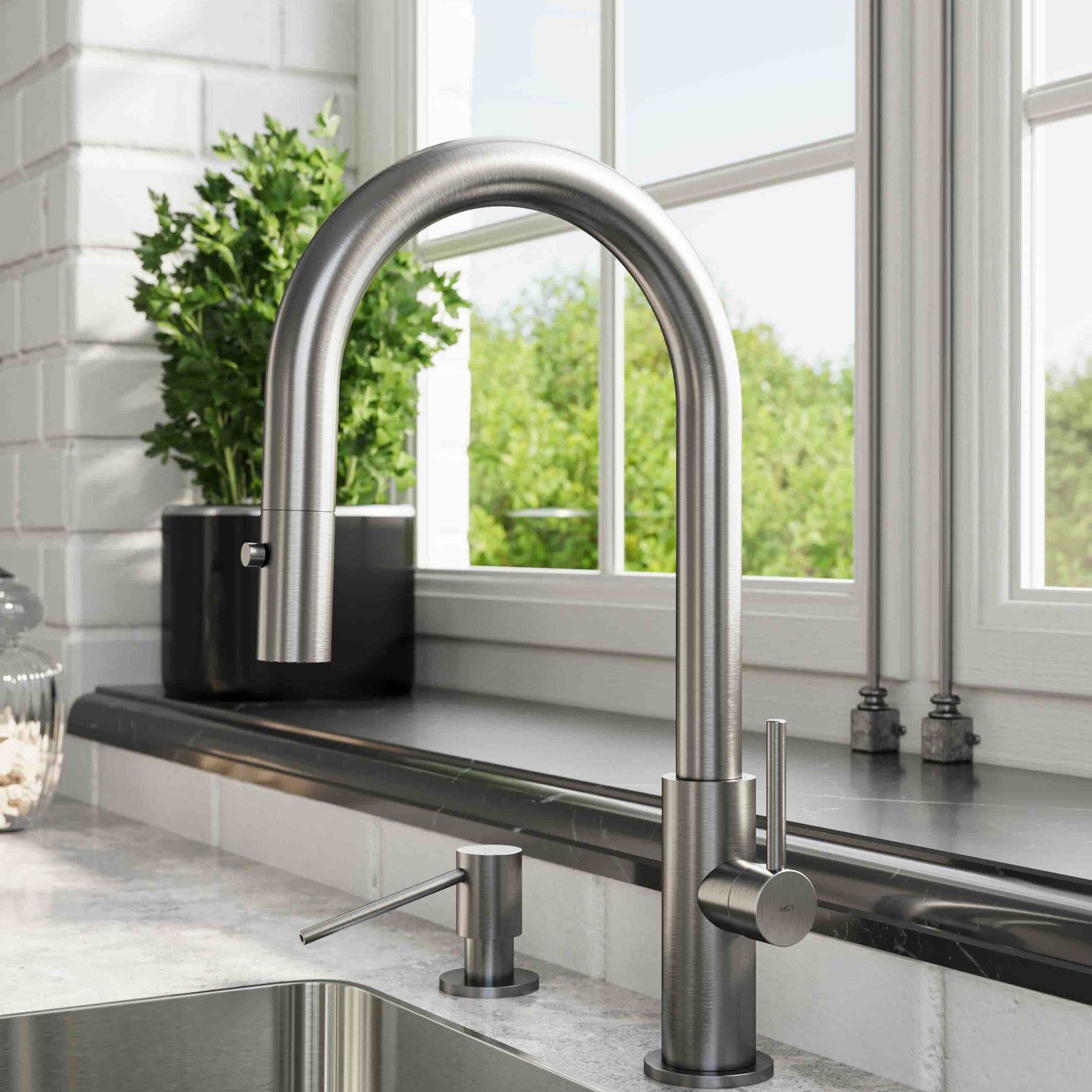 Modern stainless steel kitchen faucet and soap dispenser on a marble countertop by a window with greenery outside.