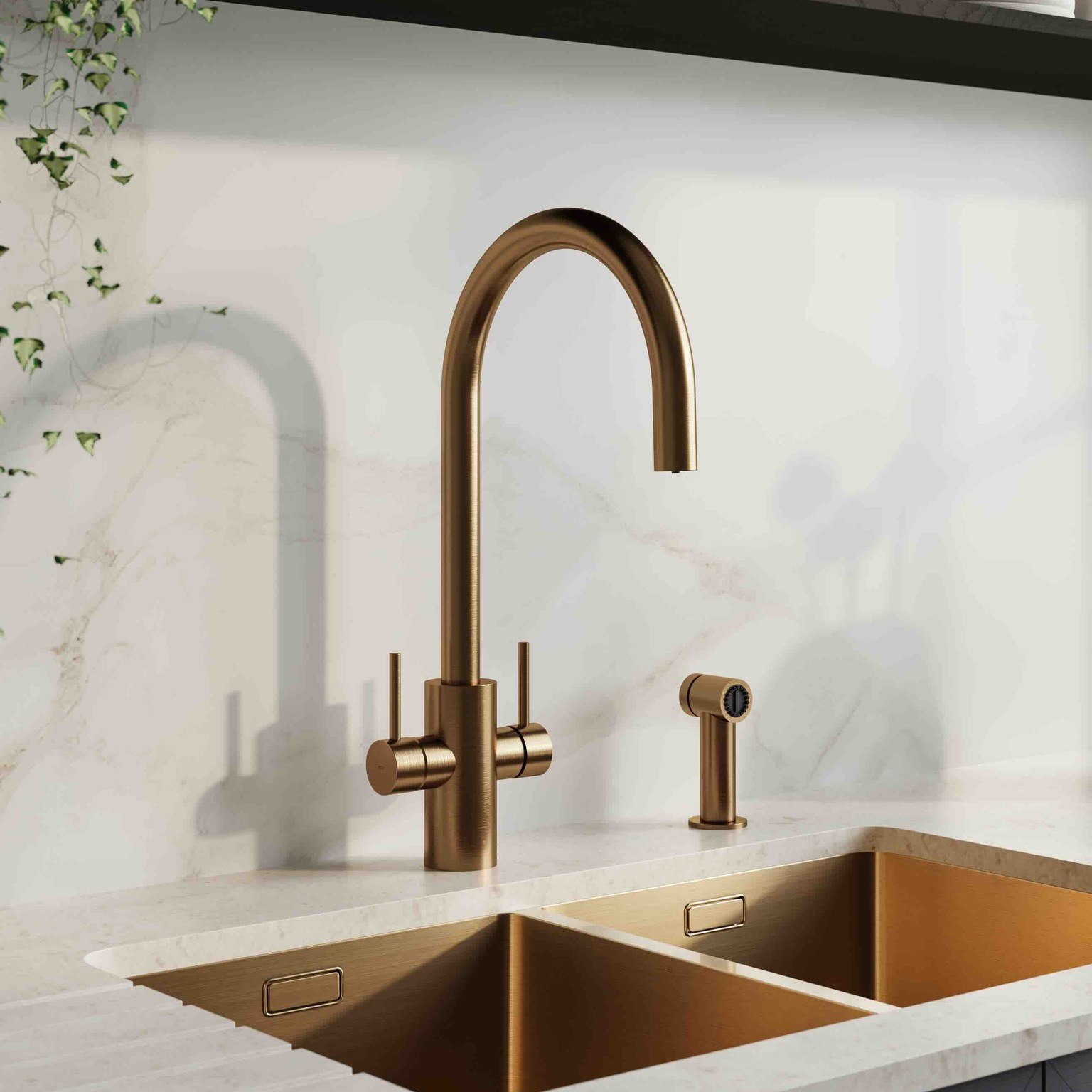 Modern kitchen sink with brushed bronze faucet and dual compartments set in marble countertop.