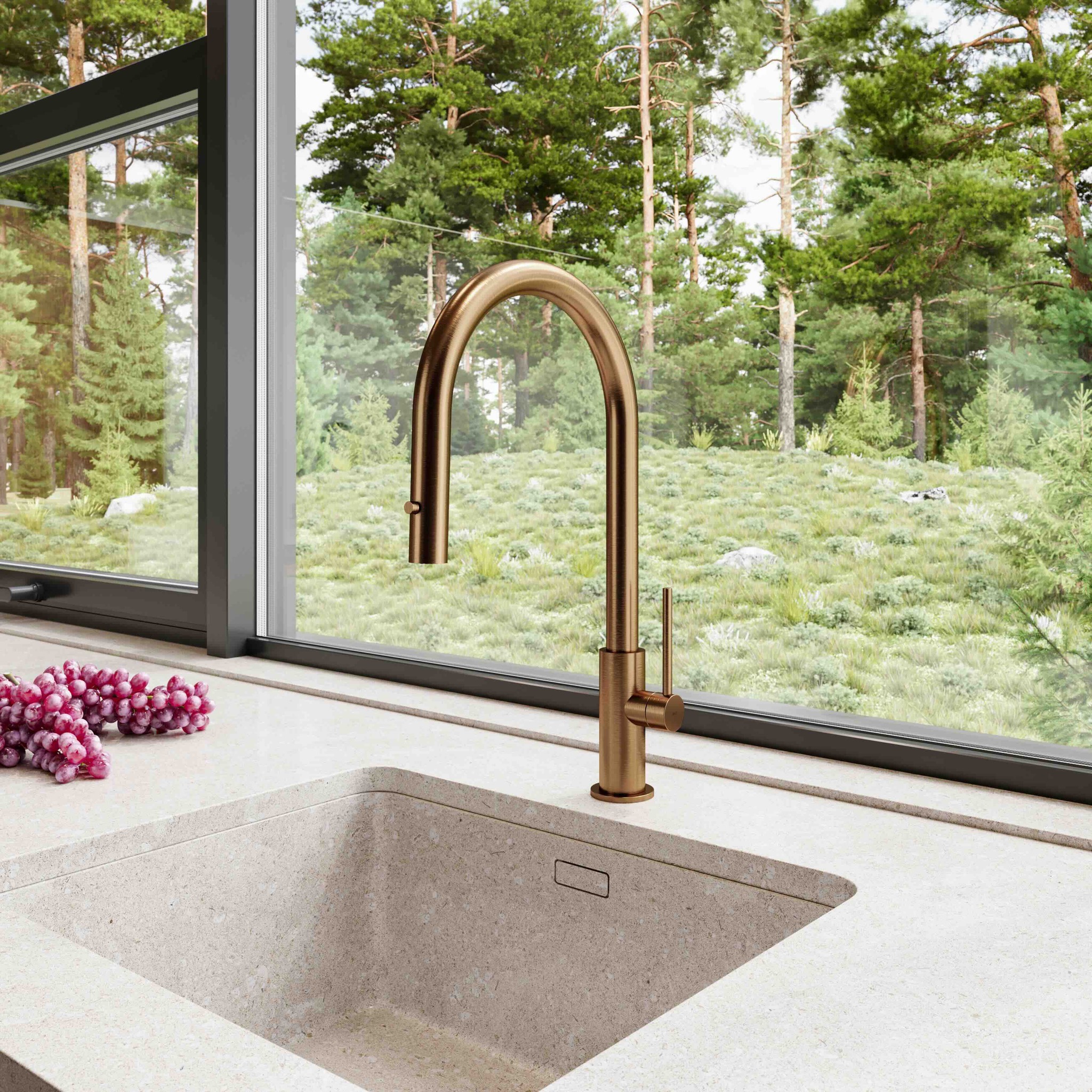 Modern kitchen sink with bronze faucet overlooking a lush green forest through a large window