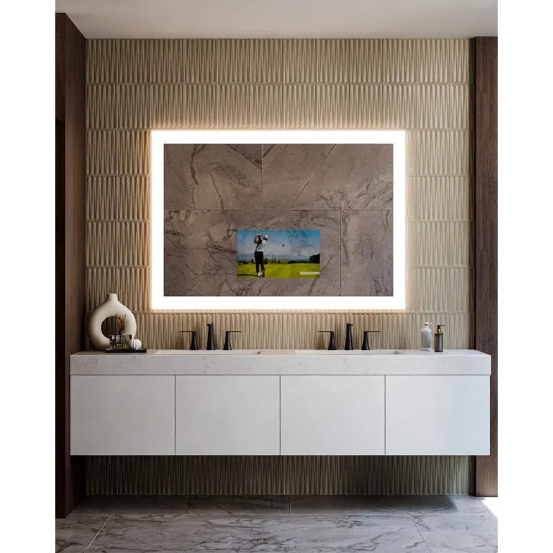 Modern bathroom vanity with double sinks, backlit mirror, textured wall, and decorative items on counter