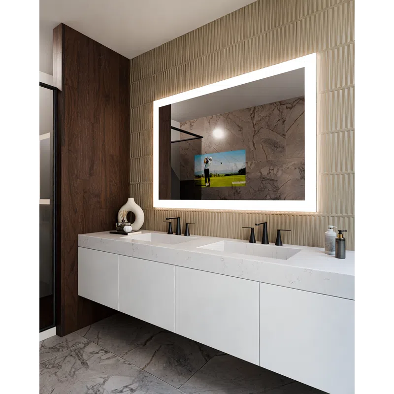 Modern bathroom with double sink, illuminated rectangular mirror, textured beige wall, and dark wood accent.
