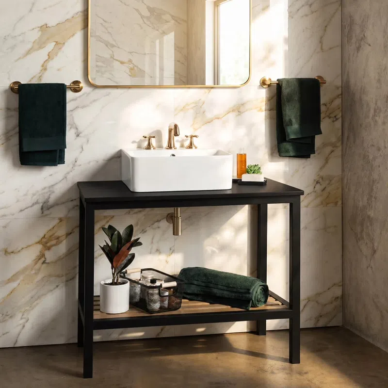 Modern bathroom with marble walls, black vanity, white sink, gold fixtures, and green towels with plant decor.