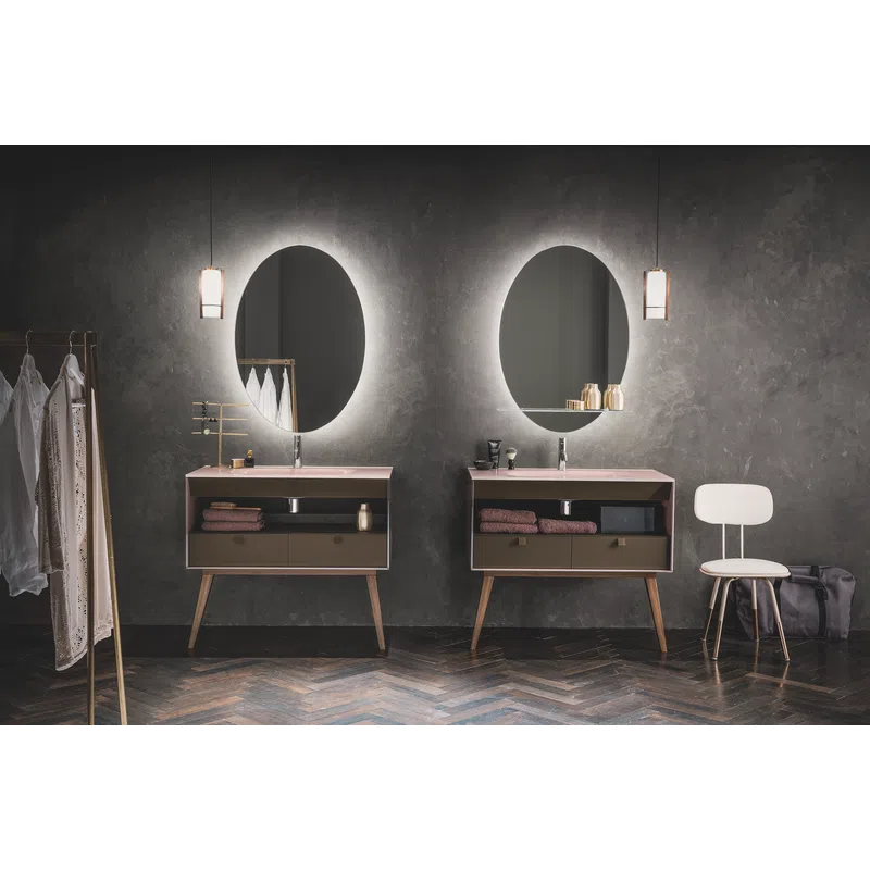 Modern bathroom with two illuminated oval mirrors, wooden vanities, hanging pendant lights, and minimalist decor.