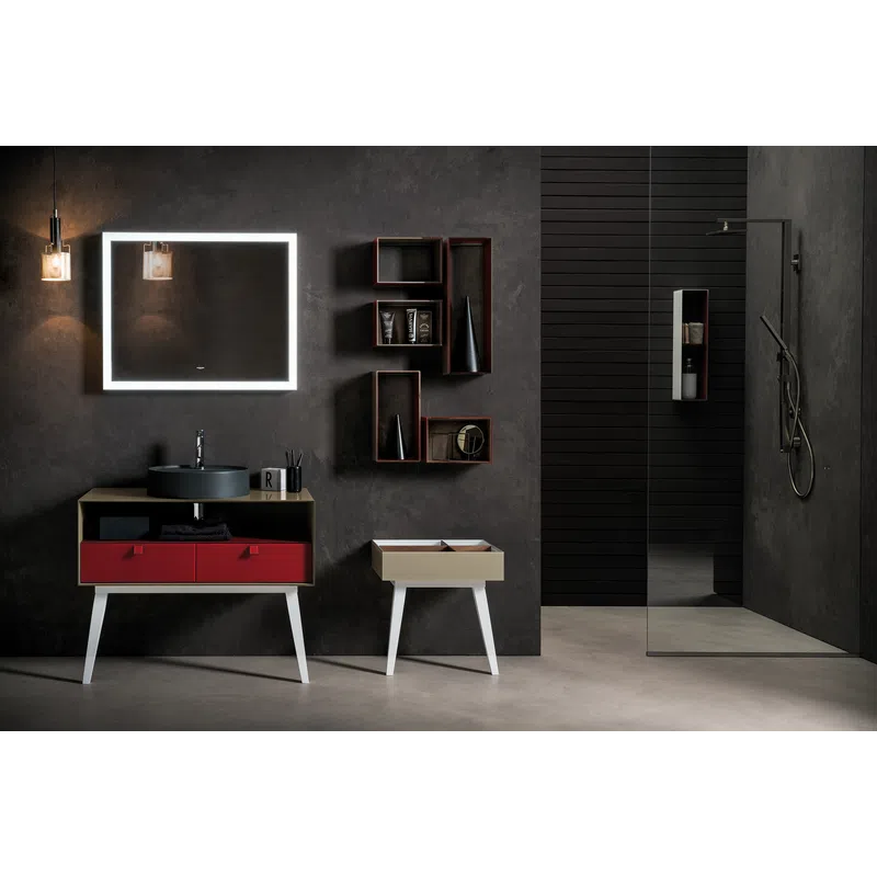 Modern bathroom with illuminated rectangular mirror, black sink on red drawer vanity, and minimalist decor.