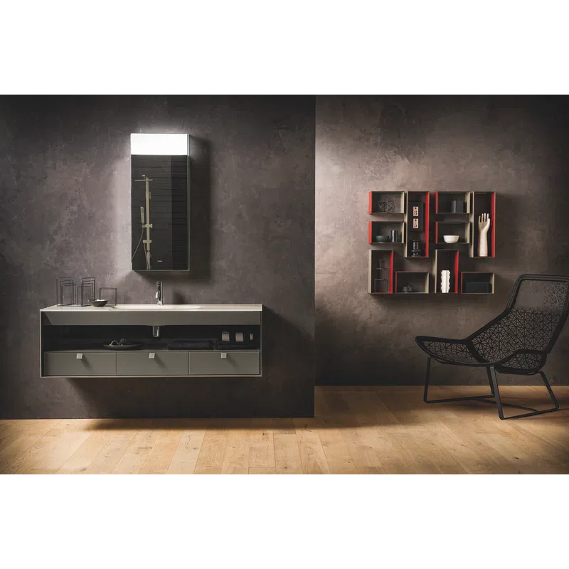 Modern bathroom with wall-mounted sink, rectangular mirror, decorative shelving, and black chair on wooden floor