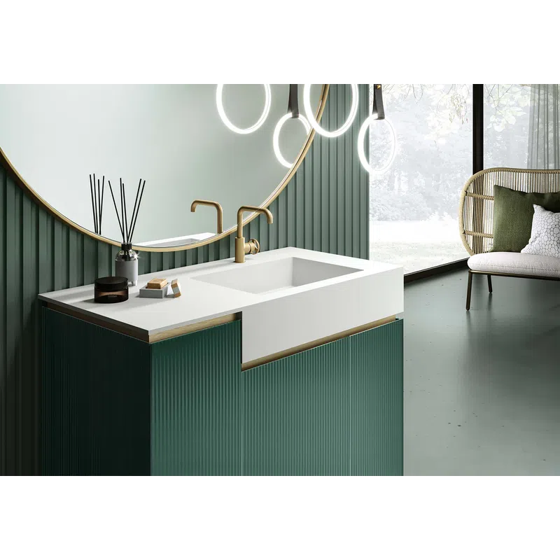 Modern bathroom with green paneled vanity, white countertop, round mirror, brass faucet, and circular pendant lights.