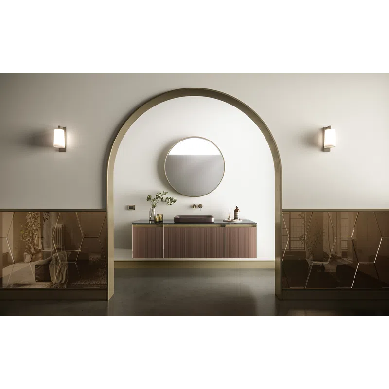 Minimalist bathroom with floating wooden vanity, round mirror, archway, and soft wall sconces lighting.