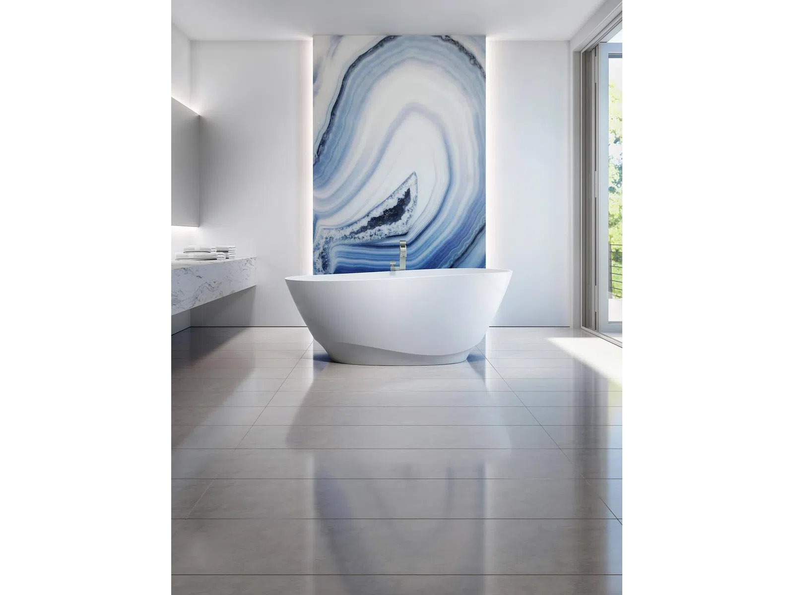 Minimalist bathroom with freestanding white tub, marble countertop, large blue agate wall art, and floor-to-ceiling window.
