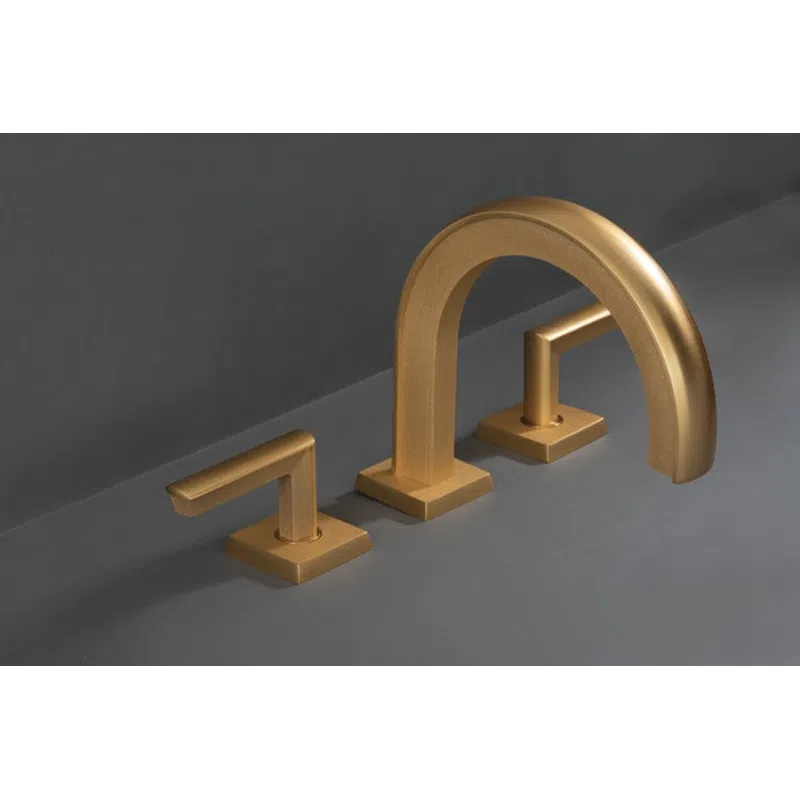 Modern matte gold bathroom faucet set with minimalist design on gray surface and background.