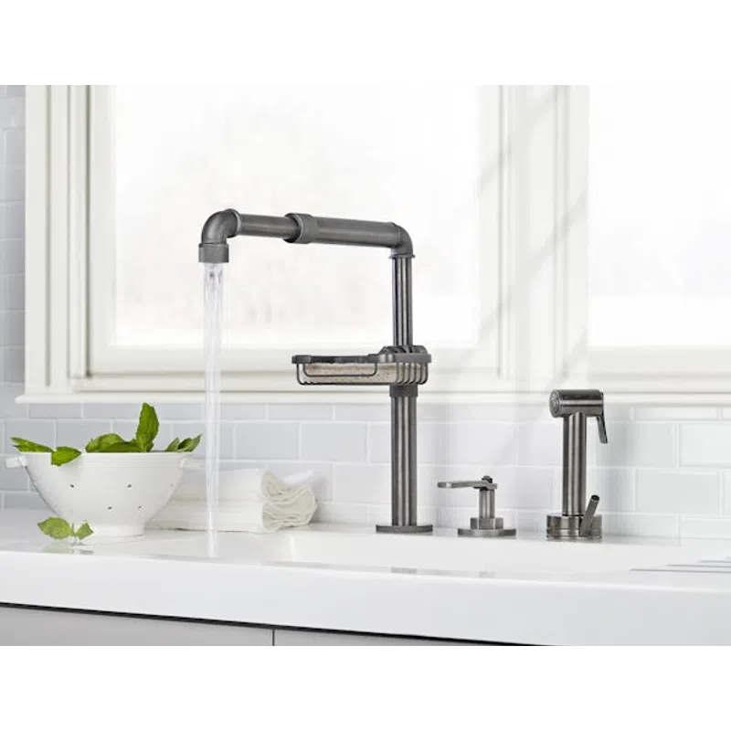 Modern industrial-style kitchen faucet with running water, soap dispenser, and vegetable sprayer on white countertop.