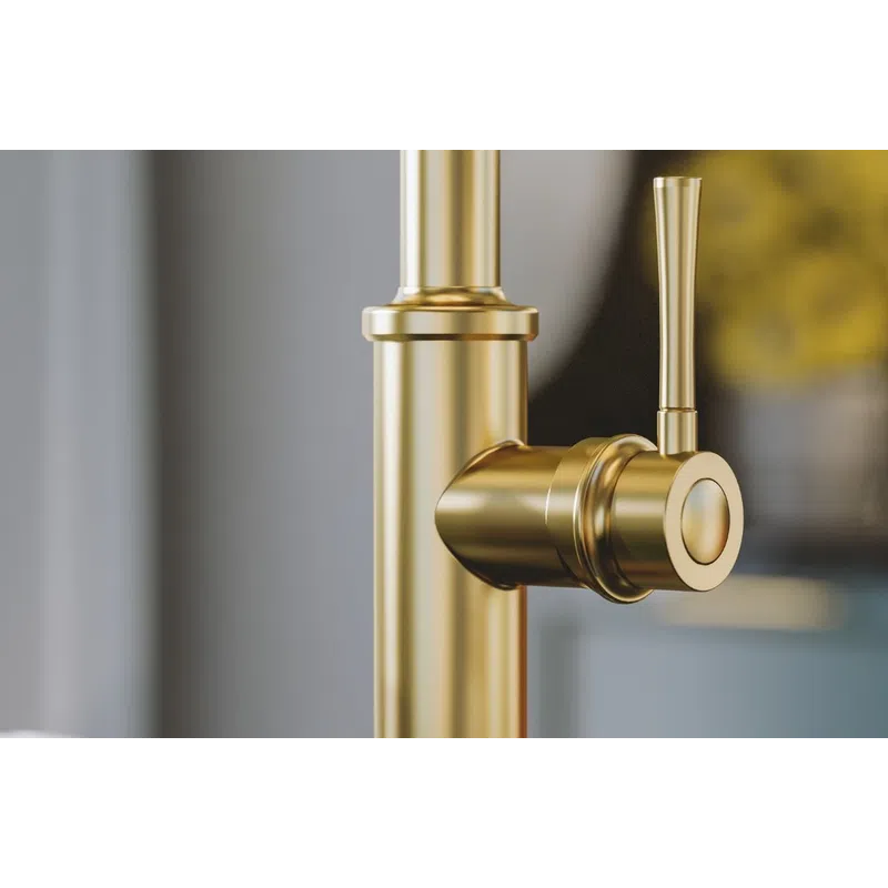 Close-up of a modern gold faucet mounted on a black marble countertop in a stylish kitchen.