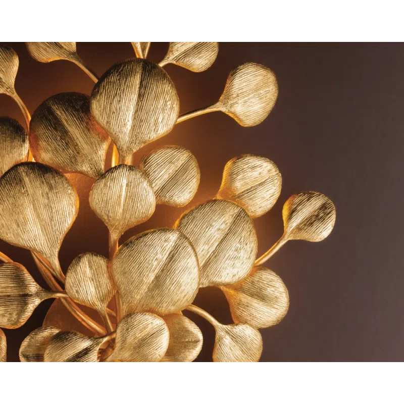 Close-up of a decorative golden metal sculpture resembling stylized leaves or seed pods with textured surfaces.