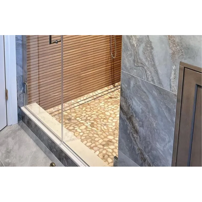 Modern shower with glass door, pebble stone floor, wooden slat wall, and gray marble tiles.