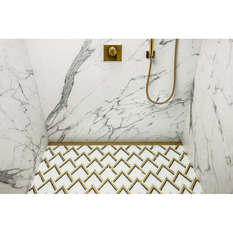 Elegant shower with white marble walls and geometric patterned floor tiles featuring gold accents and fixtures.