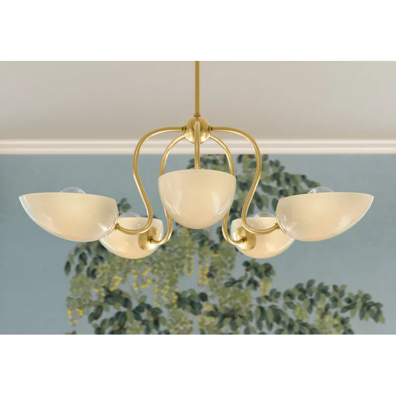 Elegant gold chandelier with four cream-colored glass shades hanging against a floral blue-green wallpaper background