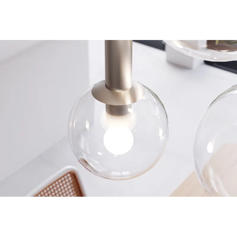 Modern pendant light with a clear glass globe and white bulb in a bright minimalist interior setting.