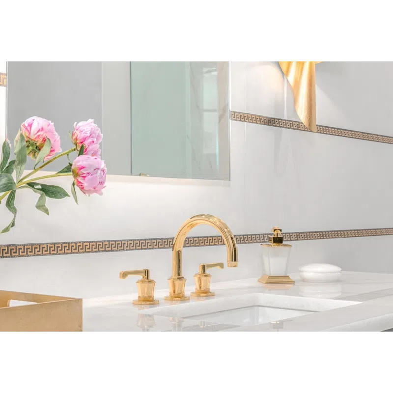 Elegant bathroom sink with gold faucet, black cabinetry, marble countertop, and pink flowers in a vase.
