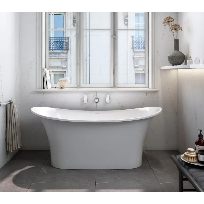 Modern white freestanding bathtub in a bright bathroom with large window and minimal decor