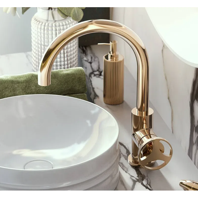 Modern bathroom sink with a sleek round white basin and elegant gold faucet on marble countertop.