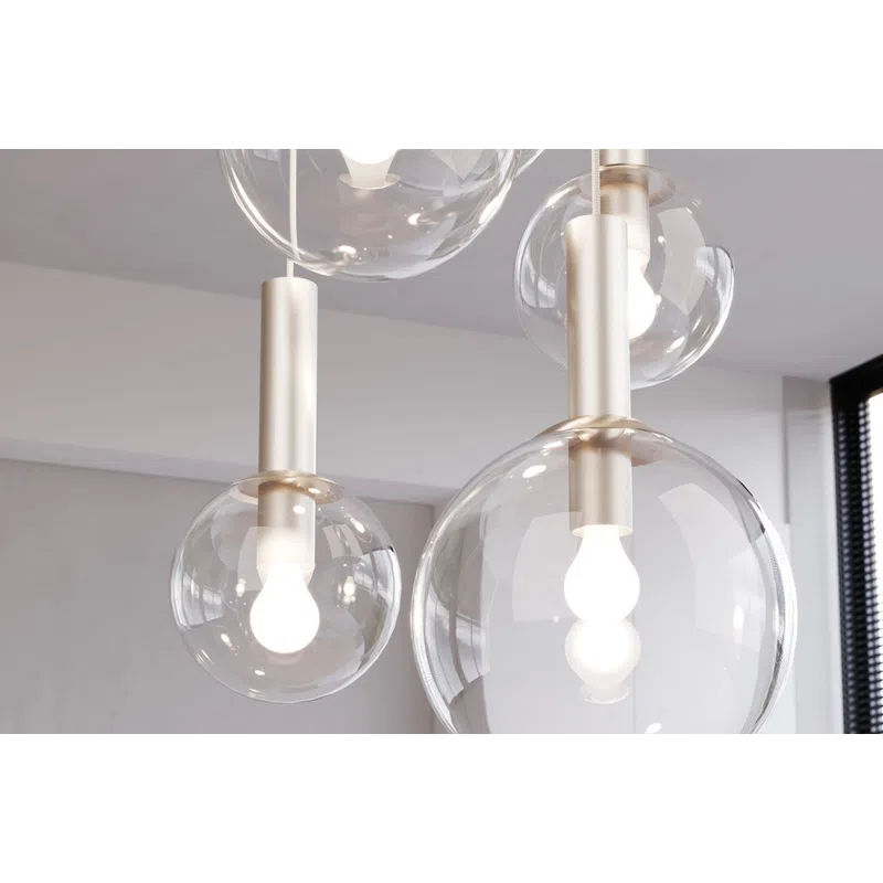 Modern pendant lights with clear glass globes and illuminated white bulbs hanging in a bright room.