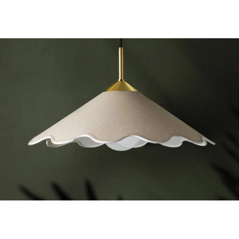 Modern pendant light with scalloped beige shade and brass fixture hanging against dark green wall.
