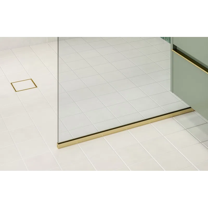 Modern bathroom shower with green tiled wall, gold fixtures, glass partition, and white tiled floor.