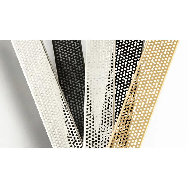 Close-up of metallic strips with perforated dot patterns in white, black, and gold colors arranged overlapping.