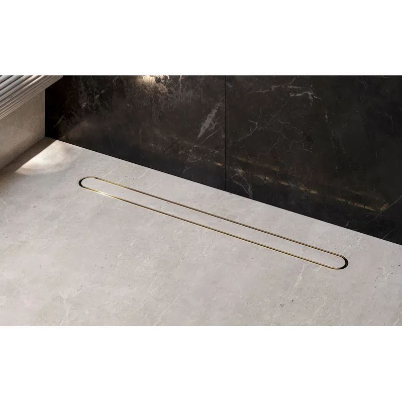 Modern linear gold shower drain set in a gray stone floor with dark marble wall background in a sleek bathroom.