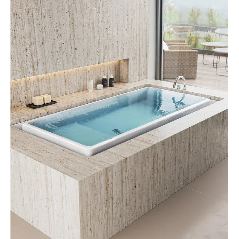 Modern bathroom with a rectangular built-in bathtub in beige stone and natural light from a large window.