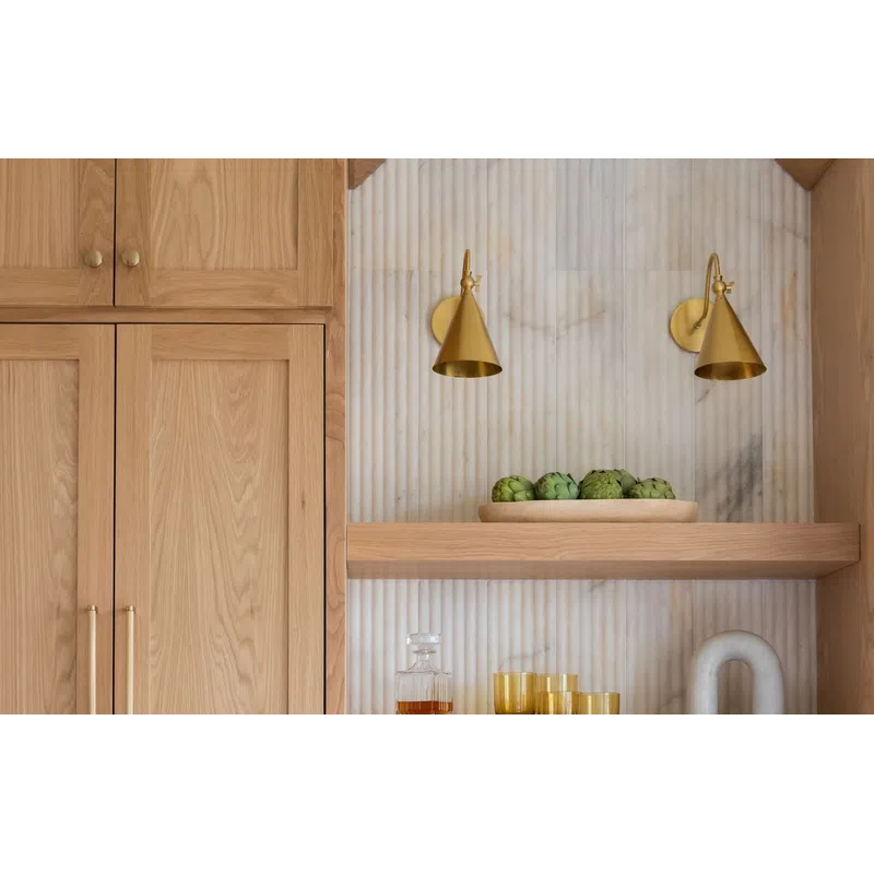 Wooden kitchen cabinets and shelves with gold accents, decorative items, and white marble countertop below.