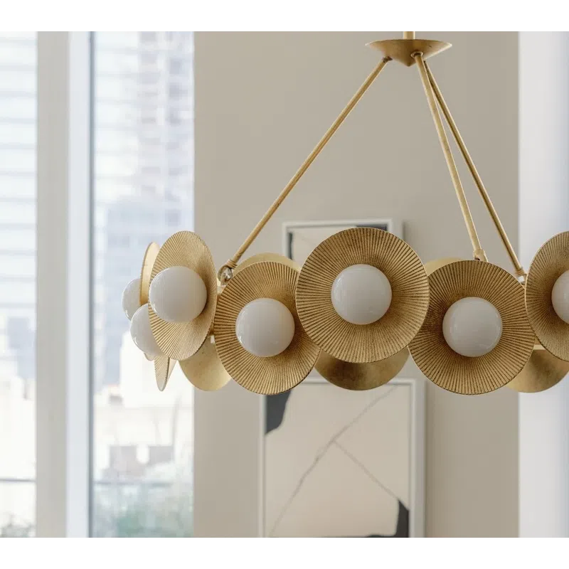 Modern gold chandelier with round white bulbs and textured circular accents in bright room.