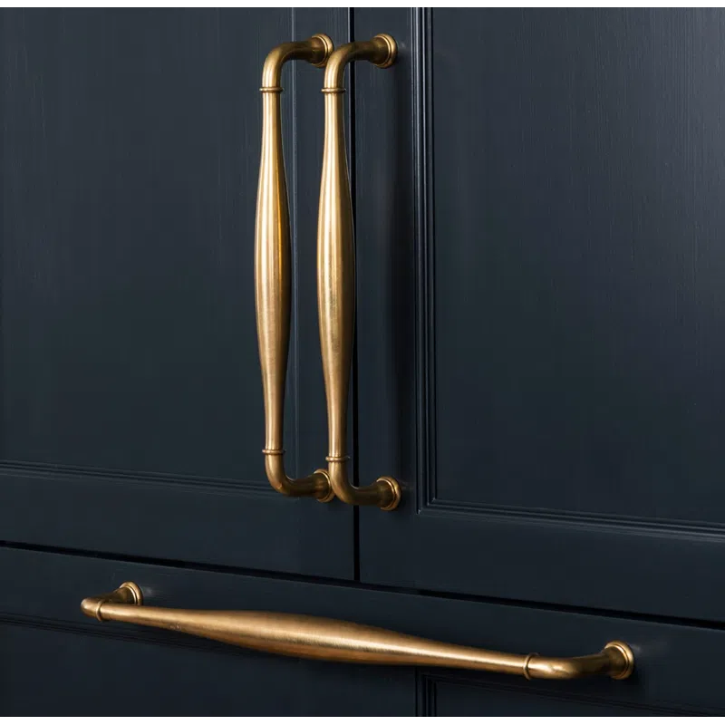 Elegant brass handles on sleek dark blue cabinet doors showcasing modern luxury design.