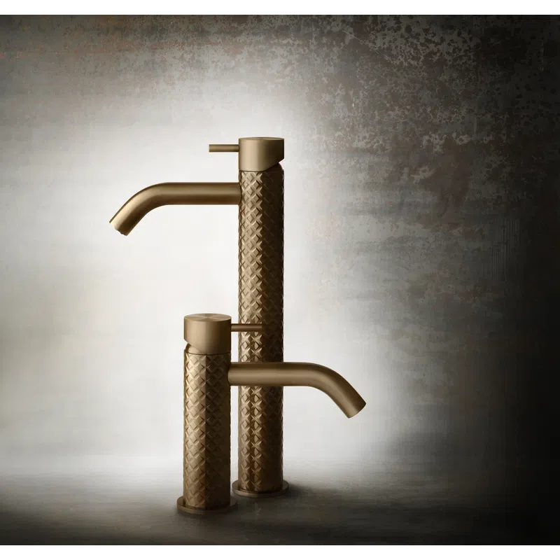 Two textured bronze faucets with a woven pattern and sleek spouts against a textured neutral background.