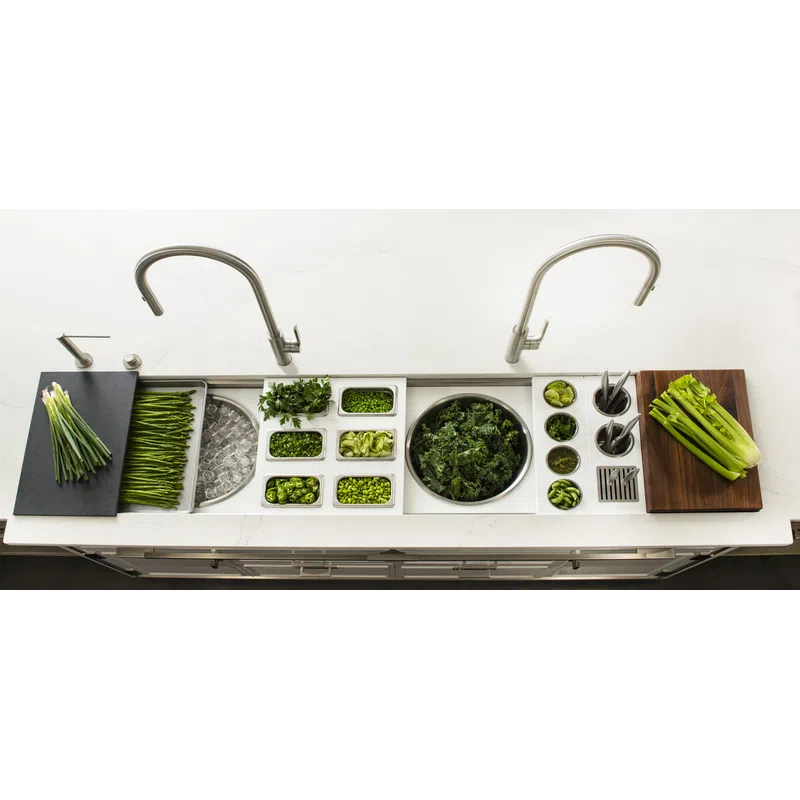 Overhead view of a modern kitchen sink with fresh green vegetables and herbs neatly arranged in compartments.