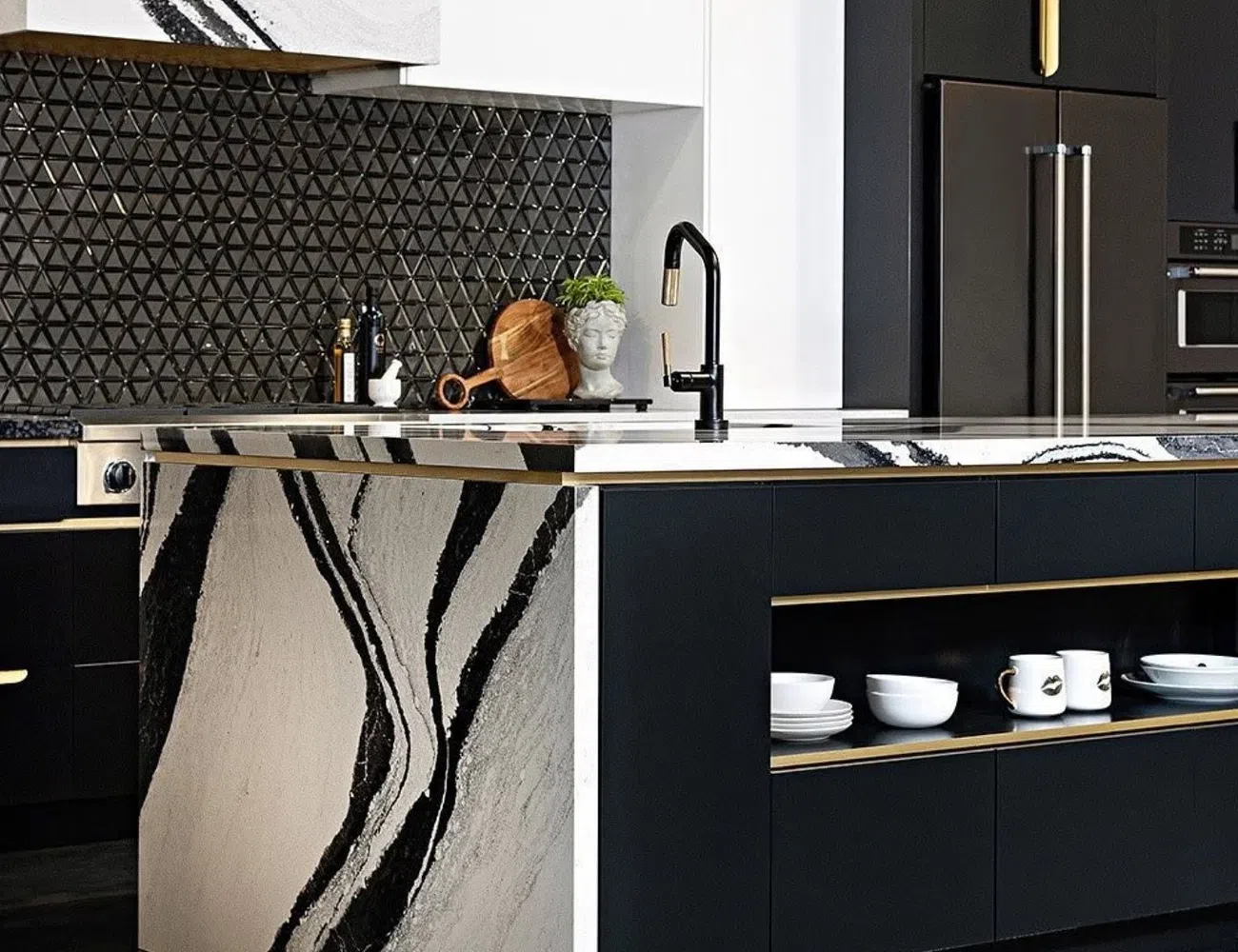 Modern kitchen with black and white marble island, matte black cabinets, and gold accents