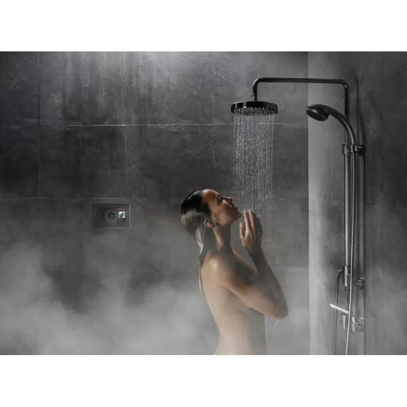 Woman enjoying a relaxing shower under a rain showerhead in a steamy modern bathroom with dark tiles.
