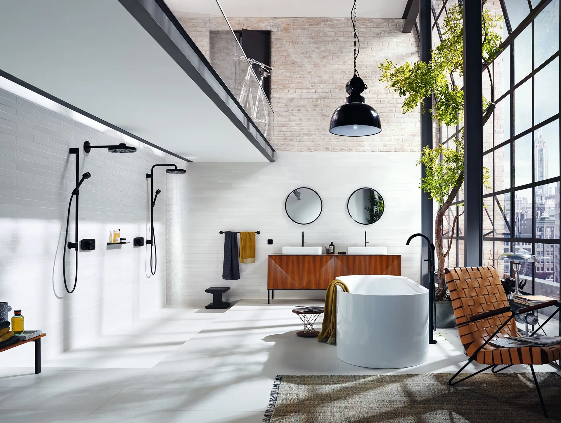 Loft-style bathroom with black AXOR shower fixtures, a freestanding tub, exposed brick, and floor-to-ceiling city view windows.